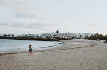 couple hugging on a white sand beach