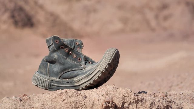 Old boot sways in the wind in Sinai desert, Egypt