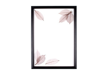 Decorative composition, black photo frame on a white background, dry leaves. Flat lay, top view, copy space.