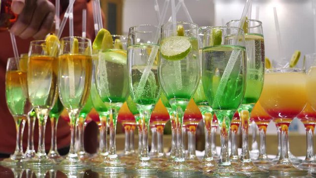 Slow motion, barman pours drinks into glasses