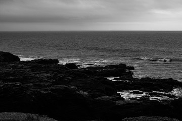 Black and white rocky shore seascape of the Atlantic coastline in France during winter