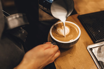 Barista making cappuccion coffee in coffee shop
