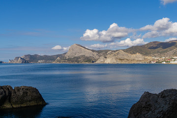 Fototapeta na wymiar Beautiful view to coast of Novy Svet village from rocky coast Alchak Cape in surroundings of resort Sudak city, Crimean peninsula.