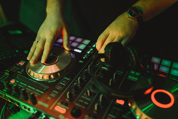 Dj mixes the track in the nightclub at a party