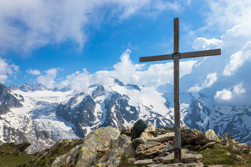 cross on the mountain peak with view of glacier