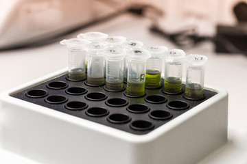 Green substance in microtube is put in thermo shaker. DNA experiment in biochemical laboratory. Synthesis of new vaccine or medicine against coronavirus.