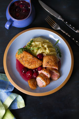 Duck breast fillet with cherry wine sauce and mashed potato on blue plate, dark background. Overhead Vertical image