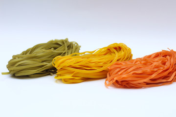 Isolated colored spaghetti nests on a white background.