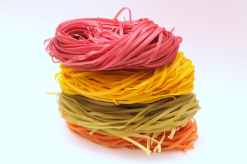 Isolated colored spaghetti nests on a white background.