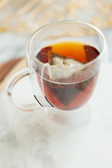 Black tea steeping in clear mug on marble