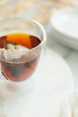 Black tea steeping in clear mug on marble