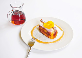 French Toast Brioche breakfast garnished with an edible pesticide free yellow pansy, drizzled with pure maple syrup and powdered sugar sprinkles