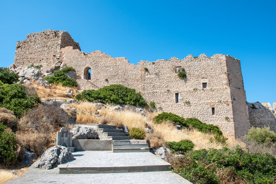 Stairs through bushes to ruins of medieval castle Kritinia (Rhodes, Greece)