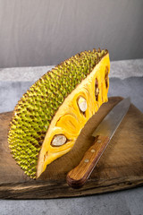 Schale der Jackfruit mit Messer und braunem Holzbrett