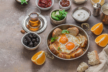 Turkish breakfast with fried eggs, cheese, vegetables, yoghurt and bread