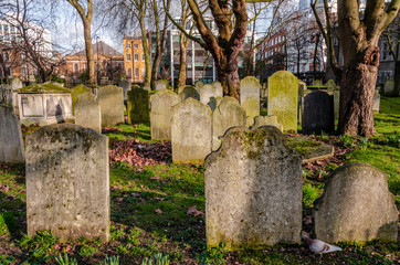 Old gravestones and headstones in a cemetery in London.