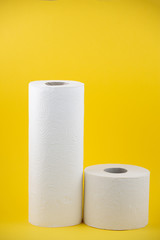 A large white toilet paper roll for use in bathrooms or kitchens, used for cleaning dirt in the bathroom on yellow background