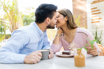 Obraz na płótnie Canvas Romantic Latin Couple Kissing At Cafe