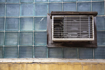 Broken retro air conditioning on a wall of glass blocks