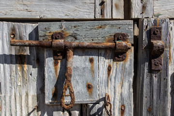 rusty old slide bolt or tower bolt on a wood antique door, old lock, rusty padlock on a wooden door