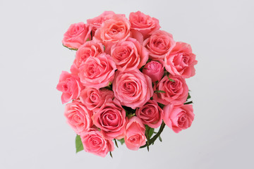 Beautiful bouquet of fresh pink roses in full bloom on white background.