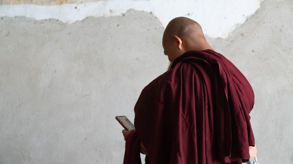 Buddhist monk looking at his phone