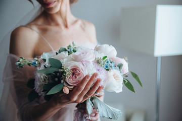 Beautiful pink and white peonies delicate wedding bouquet in hands of the bride