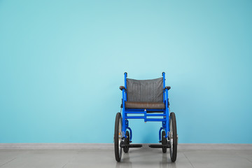 Empty wheelchair near color wall