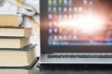 Open Laptop with Books and Newspapers Stacked on its Keyboard in front of Window. News and Information on Paper Pages or Computer Screen, Business Concept