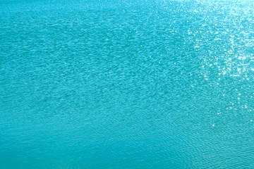 Blurry image of calm blue water texture. Abstract nature texture background. Cropped shot of an ocean. Water, travel, nature concept.