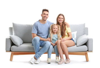 Happy young family sitting on sofa against white background