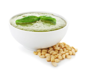 Bowl with tasty pesto sauce on white background