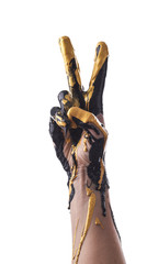 Female refined hand smeared with black and gold acrylic paint on a white background