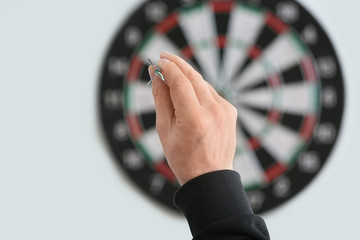 Young man playing darts indoors