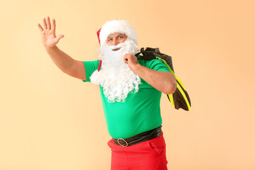 Fototapeta na wymiar Santa Claus with paddles on color background. Concept of vacation