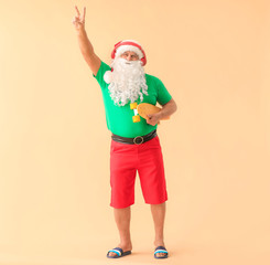 Fototapeta na wymiar Santa Claus with skateboard on color background. Concept of vacation