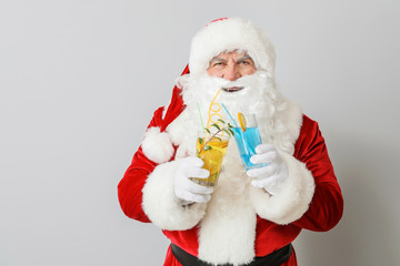 Santa Claus with cocktails on light background. Concept of vacation