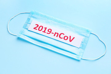 Protective mask with text 2019-nCoV on color background