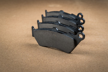 A set of 4 new motorcycle brake pads standing on a wooden board or working desk, waiting to be installed onto the motorcycle. © Anze