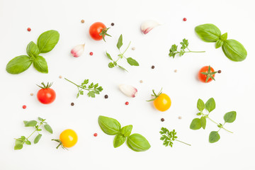 Fresh cherry tomatoes, oregano, basil, parsley, garlic, peppercorns on white background. Top pattern. Top view.