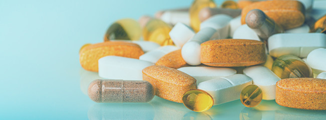 Panoramic macro photo of medication pills, medicine tablets, dietary supplements or drugs with copy space, toned