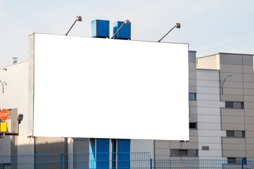 Blank white advertising billboard in the front of the factory building