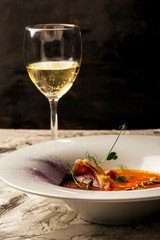 Cream of pumpkin soup puree with the addition of fried bacon. glass of white wine. author menu
