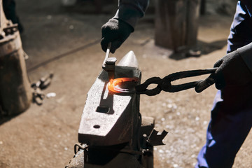 blacksmith forges a horseshoe, close-up