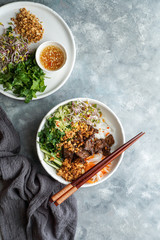 bowl of traditional Vietnamese noodle salad - Bun Bo Nam Bo, with beef, rice noodles, fresh herbs, pickled vegetables and fish sauce