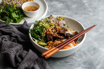 bowl of traditional Vietnamese noodle salad - Bun Bo Nam Bo, with beef, rice noodles, fresh herbs,...
