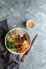 bowl of traditional Vietnamese noodle salad - Bun Bo Nam Bo, with beef, rice noodles, fresh herbs, pickled vegetables and fish sauce