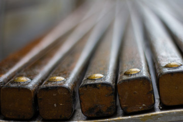 Holzstäbe einer Parkbank mit goldenen Schraubenköpfe