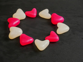 Red and white jelly hearts on dark background. Abstract love and Saint Valentine background.