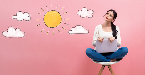 Sunny day with young woman using a laptop computer